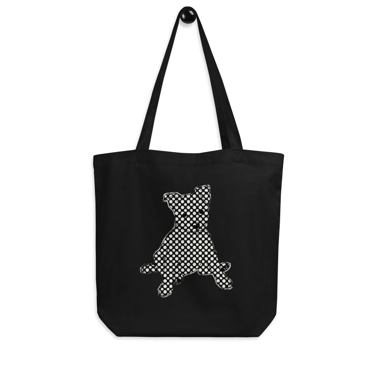 Black 'polka dots pup' canvas tote bag hanging on a hook, dog silhouette in a black and white polka dot pattern, cozy bluesky