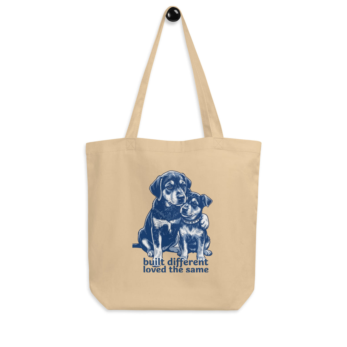 Oyster 'built different, loved the same' canvas tote bag on a hook, different breeds, same love, cozy bluesky