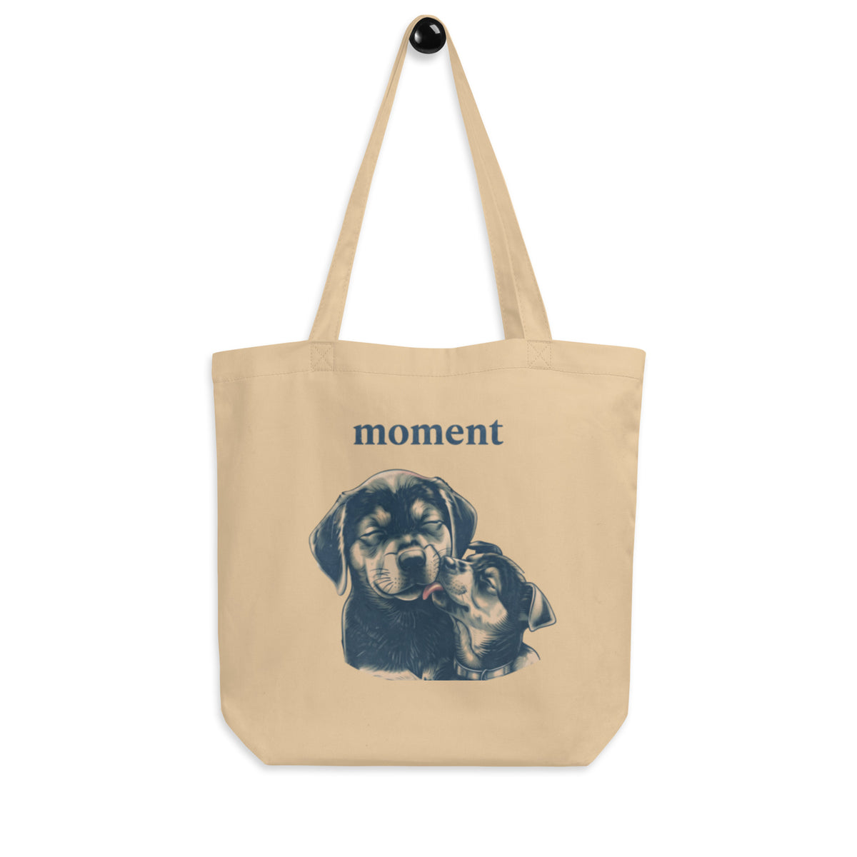 Oyster 'moment, closer' canvas tote bag hanging on a hook, big dog nuzzling a small dog under the word moment, cozy bluesky