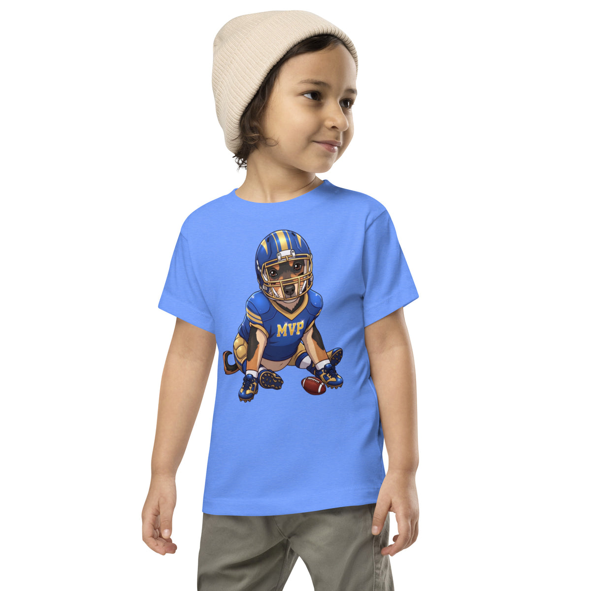 Child in a beanie wearing a heather columbia blue 'football MVP' toddler t-shirt, dog in a football helmet and MVP jersey